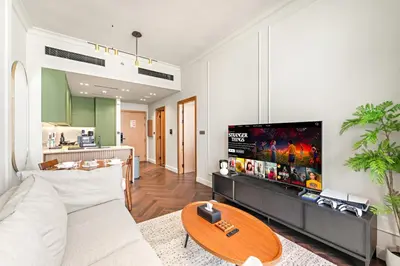 a living room with a couch and a table at Modern 1BR Apartments by Nestovia in JVC with Pool and City Views in Dubai
