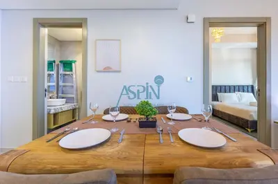a wooden table with plates and wine glasses on it at Aspin 2BHK- Stay in the heart of Dubai- 45th floor in Dubai