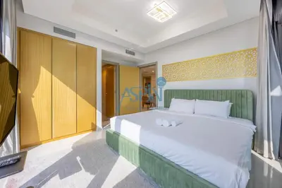 a bedroom with a large white bed with a green headboard at Aspin 2BHK- Stay in the heart of Dubai- 45th floor in Dubai