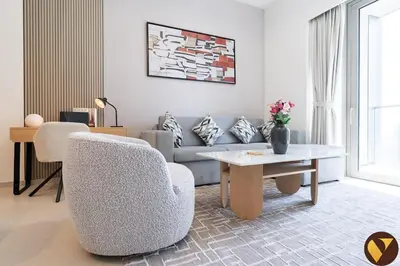 a living room with a couch and a table at Vogue Downtown Grande Signature Residences, near Dubai Mall and Burj Khalifa, Two-Bedroom Apartment with Large Balcony, Infinity Pool with Burj Khalifa View, Access to all Amenities in Dubai