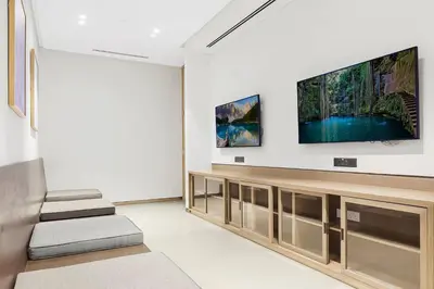 a living room with a flat screen tv on a wall at Vogue Downtown Grande Signature Residences, near Dubai Mall and Burj Khalifa, Two-Bedroom Apartment with Large Balcony, Infinity Pool with Burj Khalifa View, Access to all Amenities in Dubai
