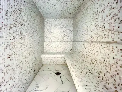 an empty room with white tiles on the wall at Azizi Riviera 63 in Dubai