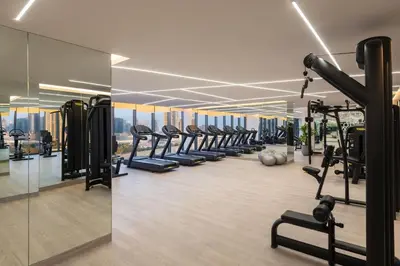 a gym with a row of treadmills and machines at DAMAC Maison AYKON City C 3 Bedrooms Walk to Metro Sleeps 8 in Dubai