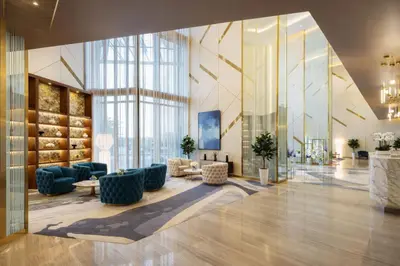 a lobby with blue furniture and a large window at DAMAC Maison AYKON City C 3 Bedrooms Walk to Metro Sleeps 8 in Dubai