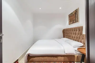 a bed in a room with a white bedspread at Downtown Zaafaran 2, in Dubai