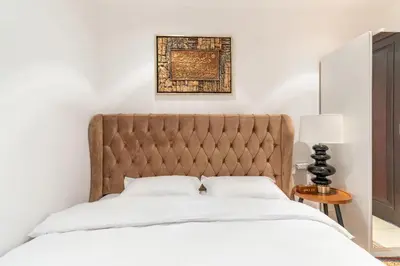 a bed with a tufted headboard in a bedroom at Downtown Zaafaran 2, in Dubai