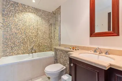 a bathroom with a sink and a toilet and a tub at Downtown Zaafaran 2, in Dubai