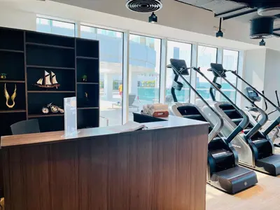 an office with treadmills and a desk with exercise equipment at Skyline 22 1 Residence in Dubai