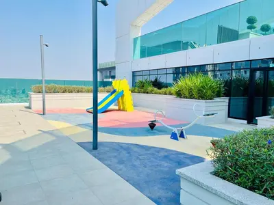 a playground with a slide in front of a building at Skyline 22 1 Residence in Dubai