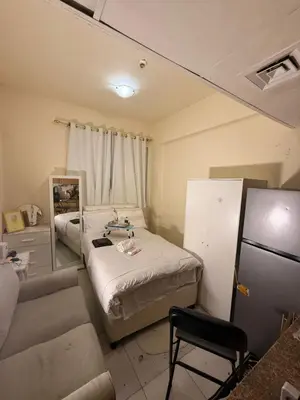 a room with a bed and a couch and a refrigerator at ShortStayDubai in Dubai