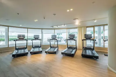 a gym with four treadmills in a room with windows at Balcony with Majestic Sea and Palm View with Assistant Room, Private Beach Access, Minutes from Marina and Palm Jumeirah Destinations, Emaar Beachfront by Deluxe Holiday Homes in Dubai