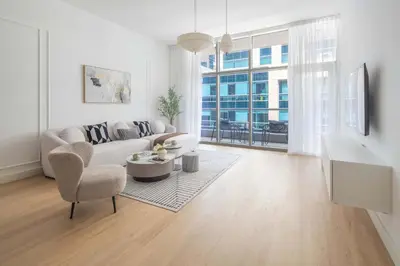 a living room with a couch and a table and chairs at Frank Porter - Bay Square 1 in Dubai
