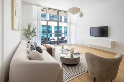 a living room with a white couch and chairs at Frank Porter - Bay Square 1 in Dubai