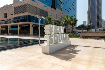 a sign that says buy sau in front of a building at Frank Porter - Bay Square 1 in Dubai