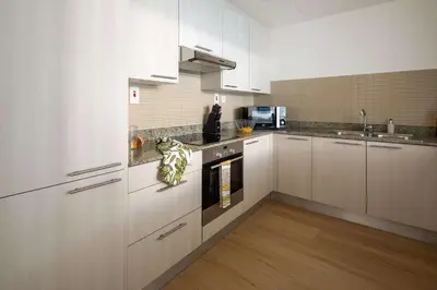 a kitchen with white cabinets and a stove top oven at Frank Porter - Bay Square 1 in Dubai