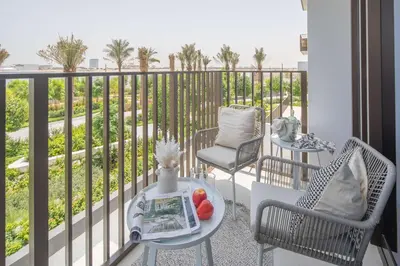 a balcony with two chairs and a table with fruit on it at Frank Porter - Creek Crescent Tower in Dubai