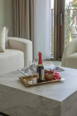 a table with a bottle of wine and a plate of food at Frank Porter - Creek Crescent Tower in Dubai