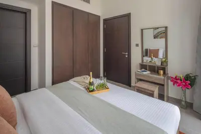 a bedroom with a bed with a bottle of champagne at Frank Porter - Merano Tower in Dubai