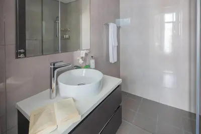 a bathroom with a sink and a book on a counter at Frank Porter - Merano Tower in Dubai