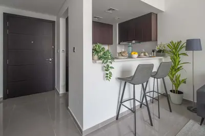 a kitchen with two bar stools and a counter at Frank Porter - Merano Tower in Dubai