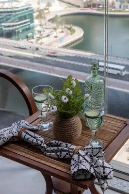 a table with a glass bottle and a plant on it at Frank Porter - No, 9 Dubai Marina in Dubai