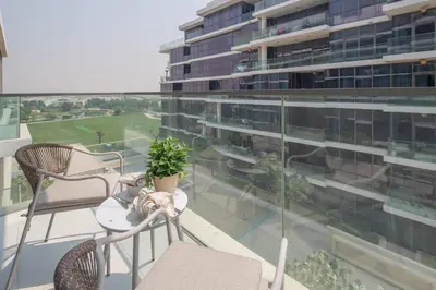 a balcony with chairs and a table and a building at Frank Porter - Loreto 3 in Dubai