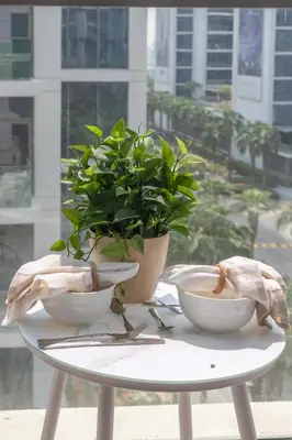 a table with two bowls and a potted plant on it at Frank Porter - Loreto 3 in Dubai