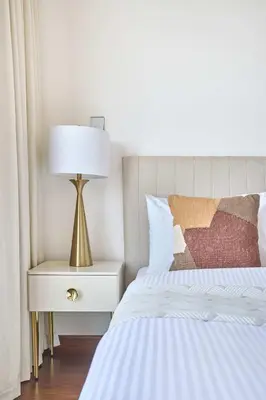 a bedroom with a bed and a lamp on a nightstand at Frank Porter - National Bonds Residence in Dubai