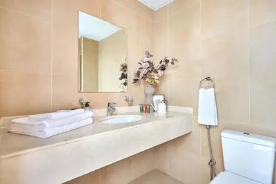 a bathroom with a sink and a mirror and a toilet at Frank Porter - National Bonds Residence in Dubai