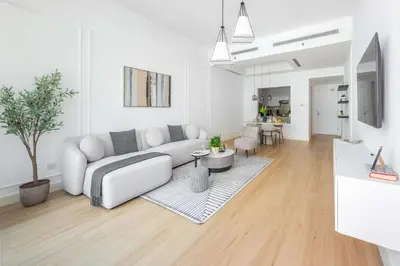 a white living room with a couch and a table at Frank Porter - Bay Square 1 in Dubai