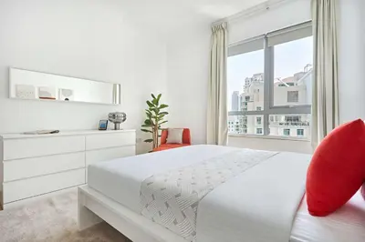 a white bedroom with a white bed and a window at Frank Porter - Residences Tower 1 in Dubai