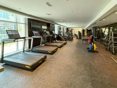 a gym with a row of treadmills and machines at Frank Porter - Residences Tower 1 in Dubai