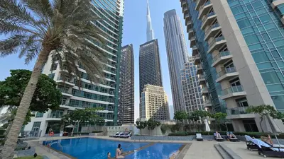 a swimming pool in a city with tall buildings at Private 2BR Oasis with Jacuzzi, Massage Chair, PS5, Steps Away From Opera, Dubai Mall, Dubai Fountains in Dubai