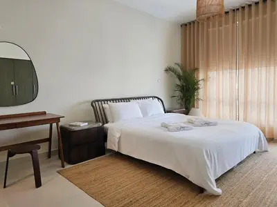 a bedroom with a bed and a table and a desk at Private 2BR Oasis with Jacuzzi, Massage Chair, PS5, Steps Away From Opera, Dubai Mall, Dubai Fountains in Dubai