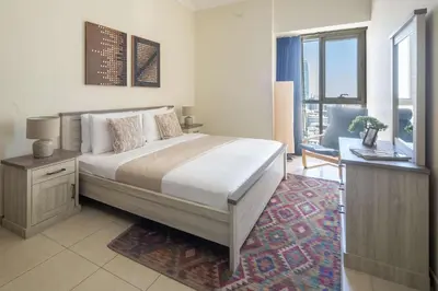 a bedroom with a bed with a desk and a window at Frank Porter - Churchill Residence Tower 2 in Dubai