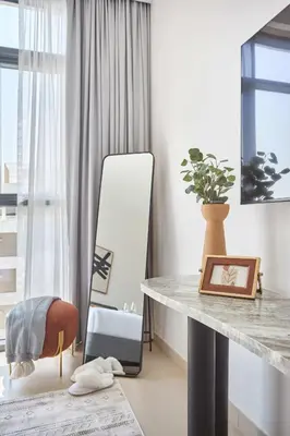 a table and a mirror in a room at Frank Porter - Azizi Park Avenue in Dubai