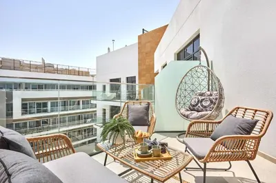 a balcony with chairs and a table on a building at Frank Porter - Azizi Park Avenue in Dubai