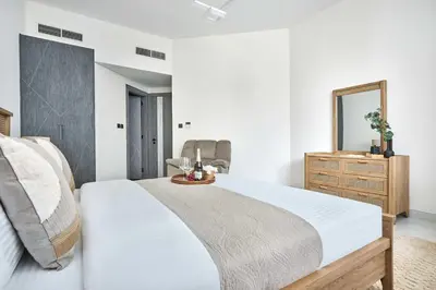 a bedroom with a bed and a mirror and a dresser at Frank Porter - Samana Park Views in Dubai