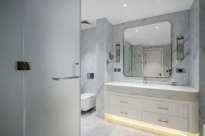 a white bathroom with a sink and a mirror at Fairmont Residence Modern 2bhk in Palm Jumeirah in Dubai