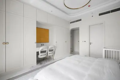 a white bedroom with a bed and two chairs at Fairmont Residence Modern 2bhk in Palm Jumeirah in Dubai
