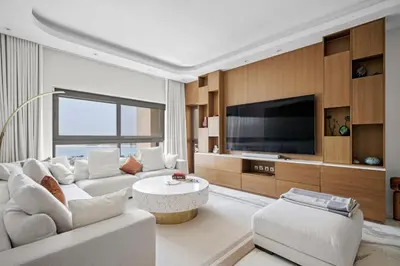 a living room with a white couch and a tv at Fairmont Residence Modern 2bhk in Palm Jumeirah in Dubai
