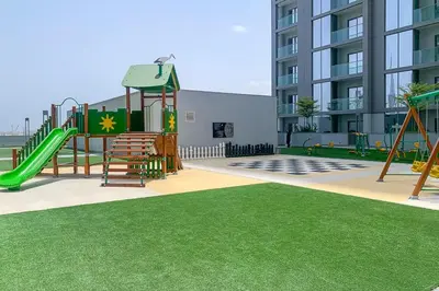 a playground with a slide and a swing set at Frank Porter - Sobha Hartland The Crest Tower C in Dubai