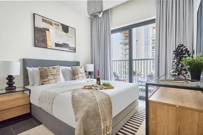 a bedroom with a large bed and a balcony at Frank Porter - Sobha Hartland The Crest Tower C in Dubai