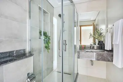 a bathroom with a glass shower and a sink at Frank Porter - The Bay in Dubai