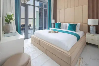 a large bedroom with a large bed with blue pillows at Frank Porter - Opalz By Danube - Tower 2 in Dubai