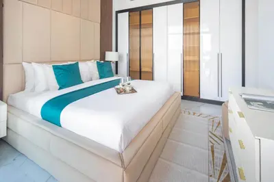 a bedroom with a large white bed with blue accents at Frank Porter - Opalz By Danube - Tower 2 in Dubai