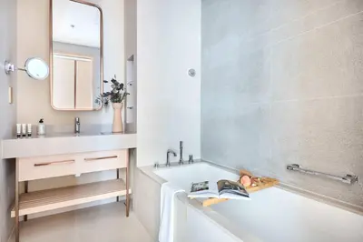 a bathroom with a tub and a sink and a mirror at Frank Porter - Vida Dubai Mall Tower 2 in Dubai