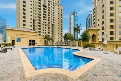 a swimming pool in the middle of a building with tall buildings at Rimal 5, JBR - 3 Bedroom with Maid's Room Apartment - Allsopp & Allsopp in Dubai