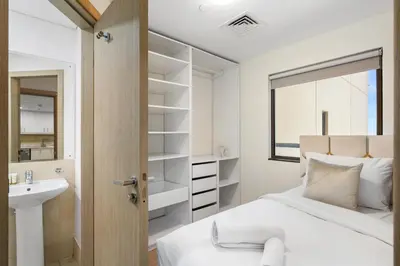 a bedroom with a bed and a sink and a mirror at Rimal 5, JBR - 3 Bedroom with Maid's Room Apartment - Allsopp & Allsopp in Dubai