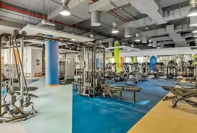 a gym with exercise equipment and blue carpet at Rimal 5, JBR - 3 Bedroom with Maid's Room Apartment - Allsopp & Allsopp in Dubai